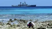 Bocah bermain di Pantai dengan latar belakang KRI Yos Sudarso 353 saat berlabuh di Miangas, Sulut. KRI tersebut memantau keamanan pulau terluar Indonesia yang berbatasan Filipina.(Antara)