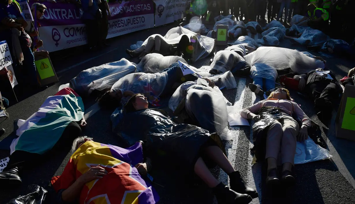 Sejumlah pengunjuk rasa berbaring dan membungkus diri dengan plastik saat melakukan aksi di Madrid, Spanyol (16/5). Dalam aksi tersebut mereka juga menuntut pemerintah agar meningkatkan daya ekonomi untuk wanita. (AFP/Javier Soriano)