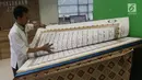 Seorang petugas membuka lembaran Alquran raksasa yang dipajang di perpustakaan Jakarta Islamic Centre, Jakarta Utara, Jumat (18/5). Alquran ini memiliki ukuran 100 cm x 50 cm dengan berat mencapai 100 kilogram. (Liputan6.com/Arya Manggala)