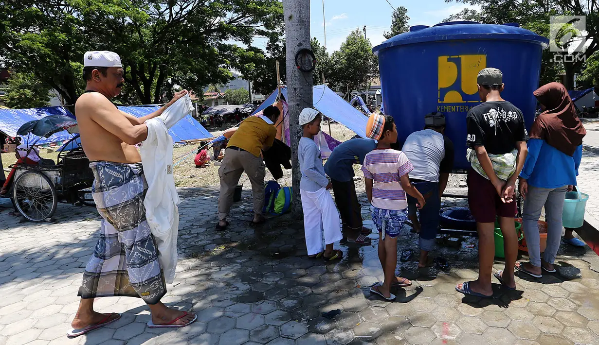 Para pengungsi mengambil wudhu jelang salat Jumat pascagempa dan tsunami di Lapangan Masjid Agung Daru Salam, Palu, Jumat (5/10). Salat digelar di lapangan karena pondasi masjid yang hancur. (Liputan6.com/Fery Pradolo)