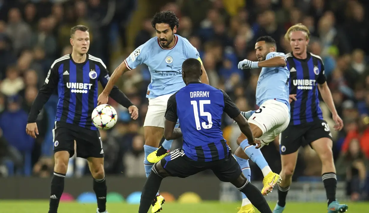 Gelandang Manchester City Ilkay Gundogan berebut bola dengan penyerang FC Copenhagen Mohamed Daramy dalam matchday ketiga Grup G Liga Champions 2022/2023 di Etihad Stadium, Kamis (6/10/2022) dini hari WIB. Dengan kemenangan ini Manchester City belum terkalahkan di fase grup Liga Champions 2022/2023. (AP Photo/Dave Thompson)
