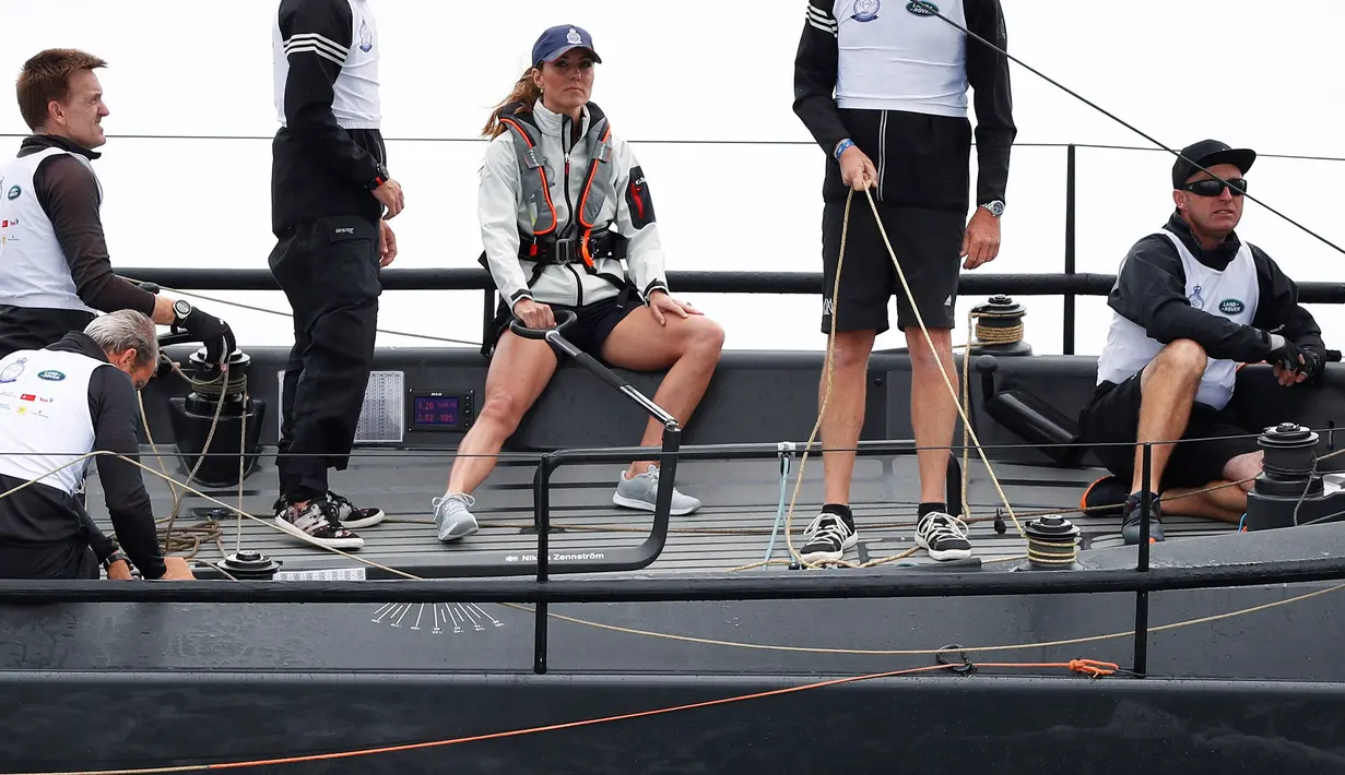 Kate Middleton (tengah) berpartisipasi dalam perlombaan perahu King's Cup Regatta di Cowes, lepas pantai selatan Inggris pada 8 Agustus 2019. Penampilan kasualnya kali ini pun mendapat sorotan publik lantaran Kate dikenal dengan penampilan anggun dan feminin. (PETER NICHOLLS/POOL/AFP)
