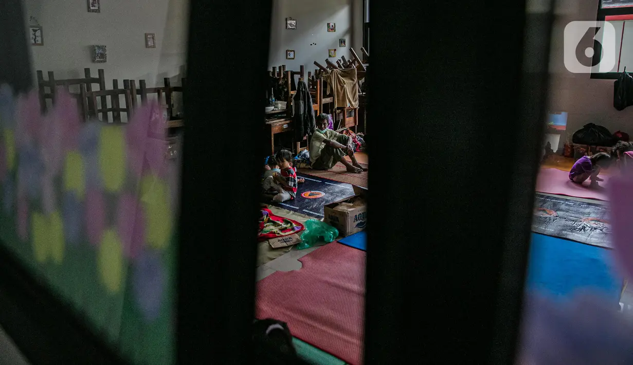 Aktivitas korban banjir di salah ruang kelas di gedung SDN 01/02 Kampung Melayu, Jakarta, Selasa (9/2/2021). Gedung sekolah di Kebon Pala tersebut menjadi salah satu posko pengungsian bagi sebagian korban banjir Kampung Melayu. (Liputan6.com/Faizal Fanani)