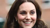 Kate Middleton tersenyum saat mengunjungi Dasar Robin Hood di London, Inggris (29/11). Kate Middleton tampil cantik mengenakan jaket berwarna cokelat dengan rambut terurai. (AFP Photo/Pool/Eddie Mulholland)