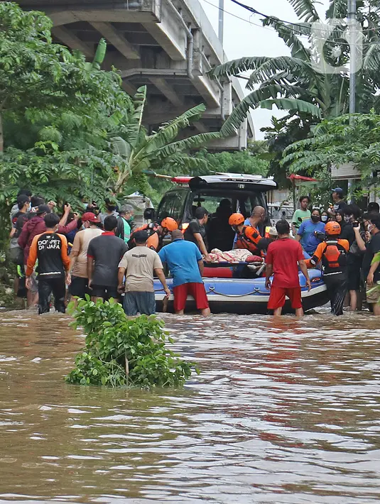 Relawan dan keluarga memasukkan jenazah warga lansia ke ambulans di tengah banjir di kawasan Cipinang Melayu, Jakarta Timur, Jumat (19/2/2021). Seorang nenek (80) meninggal di kediamannya, di lokasi banjir, di RW 04, kawasan tersebut karena sakit dan sudah lanjut usia. (Liputan6.com/Herman Zakharia)