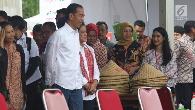 Presiden Joko Widodo didampingi Ibu Negara Iriana saat blusukan ke area persawahan untuk meninjau Gerakan Mengawal Musim Tanam Okmar 2018/2019 di Desa Leuwigoong, Garut, Jawa Barat, Sabtu (19/1). (Liputan6.com/Angga Yuniar)