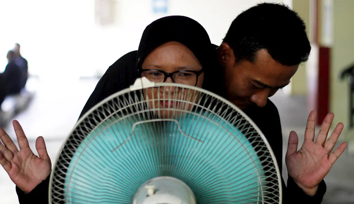 Calon pengemudi ojek online berdiri di depan kipas angin saat mengikuti tes bau badan di sebuah tempat parkir bawah tanah di Jakarta, 9 Januari 2016. Uji bau badan ini dilakukan demi meningkatkan kualitas pelayanan. (REUTERS/Garry Lotulung)