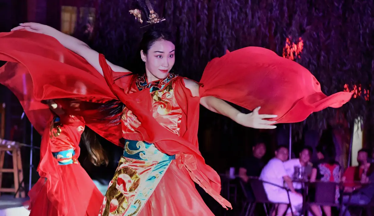 Para seniman menampilkan pertunjukan di kota kuno Luoyi di Luoyang, Provinsi Henan, China tengah, pada 7 Juli 2020. Berbagai bentuk tur malam hari di Luoyang menarik banyak wisatawan dan mendongkrak perekonomian. (Xinhua/Li An)
