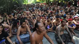 Warga Bali bersiap pergi ke hutan manggrove untuk mandi lumpur tradisional atau yang dikenal sebagai Mebuug-buugan di desa Kedonganan, Bali (18/3). Warga menggelar tradisi unik usai perayaan hari Nyepi lewat mandi lumpur. (AFP/Sony Tumbelaka)
