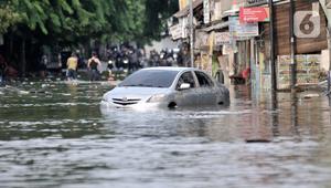 Sebuah mobil terjebak banjir di Jalan RA Kartini, Bekasi, Jawa Barat, Kamis (2/1/2020). Banjir yang merendam Jalan RA Kartini sejak kemarin melumpuhkan akses kendaraan dan perekonomian warga setempat. (merdeka.com/Iqbal Nugroho)