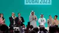 Presiden COP28 Sultan al-Jaber (tengah) bertepuk tangan di antara para pejabat lainnya pada 13 Desember 2023, di Dubai. (Giuseppe Cacace/ AFP)