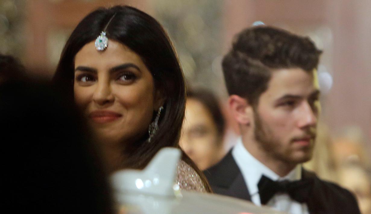 Aktris Bollywood, Priyanka Chopra dan suaminya yang juga musisi AS, Nick Jonas menghadiri pernikahan Isha Ambani dan Anand Piramal di Mumbai, Rabu (12/12). Isha merupakan putri orang terkaya di India menurut Forbes, Mukesh Ambani. (AP/Rajanish Kakade)