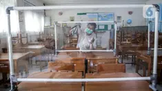 Petugas menyiapkan ruangan kelas yang akan digunakan di SMP N 115 Jakarta, Jumat (21/5/2021). Seleksi PPDB DKI Jakarta tahun ini akan dibagi menjadi empat bagian yakni jalur prestasi, jalur afirmasi, jalur zonasi, dan jalur pindah tugas orangtua dan anak guru. (Liputan6.com/Faizal Fanani)