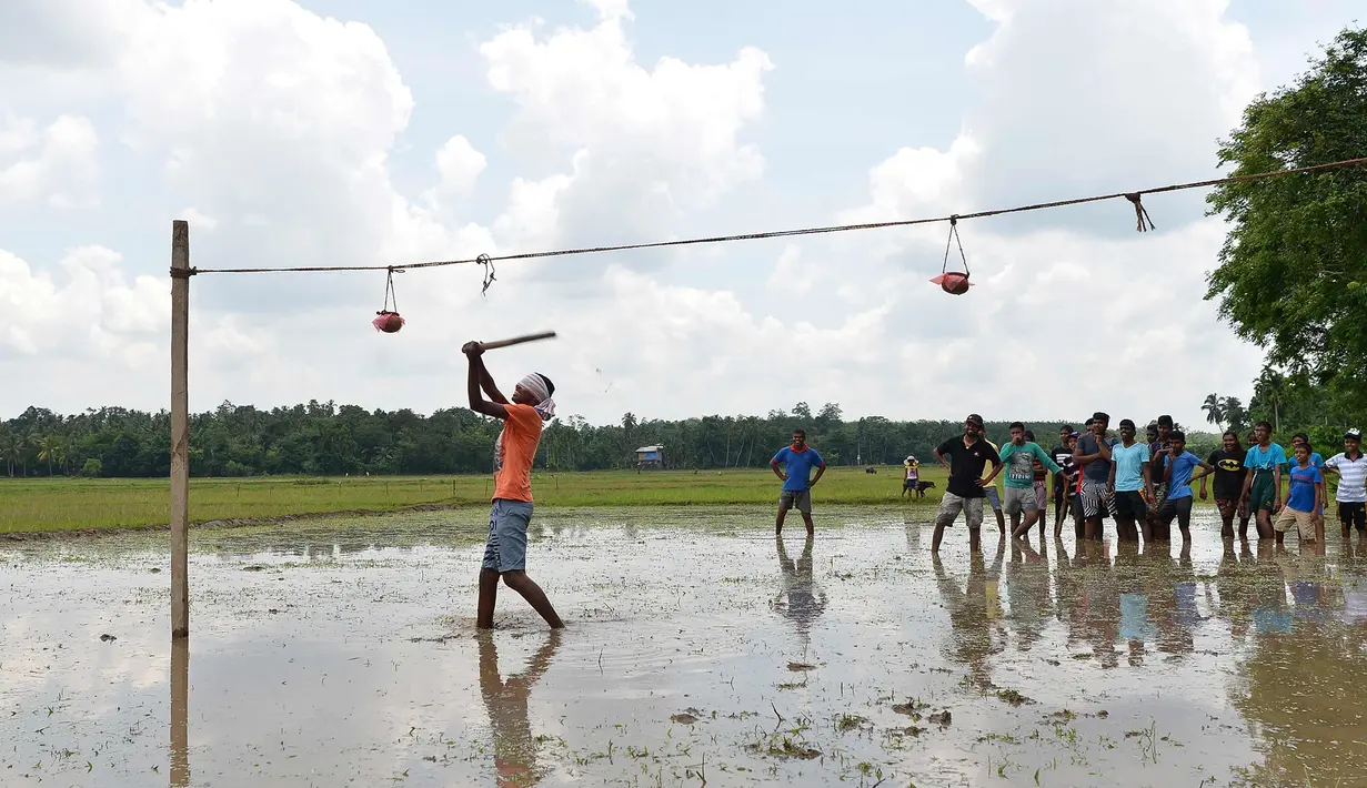Seorang pria berusaha memukul kendi selama perayaan Tahun Baru Sinhala dan Tamil di Bandaragama, Kolombo (21/4). Sejumlah perlombaan diadakan saat tahun baru umat Hindu, Sinhala dan Tamil yang jatuh 14 April. (AFP Photo/Lakruwan Wannirachchi)