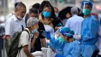 Seorang pekerja yang mengenakan pakaian pelindung menyeka tenggorokan seorang wanita untuk tes COVID-19 di fasilitas pengujian virus corona di Beijing, China, Jumat (12/8/2022). Beberapa kota di China yang dilanda COVID-19 dari timur ke barat negara itu memberlakukan pembatasan dan lockdown baru untuk menahan gejolak yang sekali lagi mengancam akan mengganggu ekonomi lokal. (AP Photo/Mark Schiefelbein)