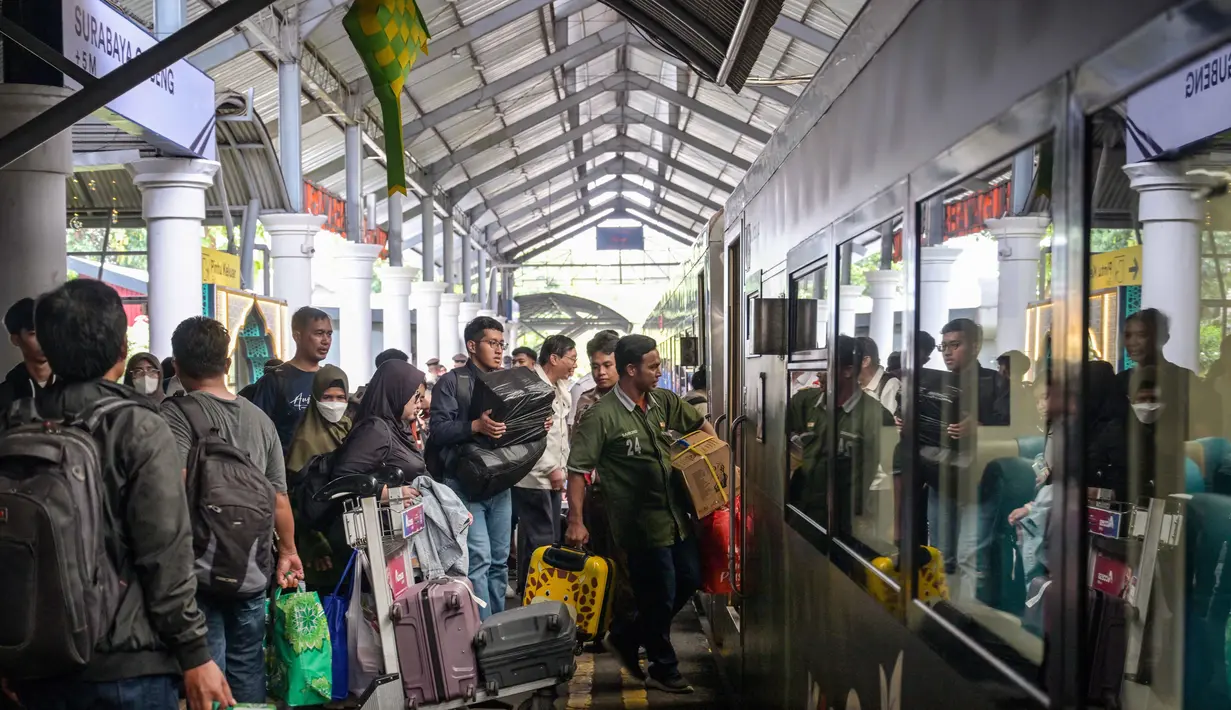 Untuk diketahui, PT KAI telah menetapkan masa Angkutan Lebaran 2026 selama 22 hari, yakni pada 11 Maret hingga 1 April 2026. Tampak dalam foto, para penumpang bersiap menaiki kereta di stasiun Gubeng, Surabaya, Jawa Timur, Selasa 17 Maret 2026. (JUNI KRISWANTO/AFP)