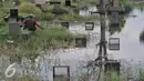 Seorang warga memancing ikan di Taman Pemakaman Umum (TPU) Tanah Kusir, Jakarta Selatan, Jumat (26/8). Warga memanfaatkan Banjir yang merendam makam di kawasan tanah kusir ini terjadi akibat luapan Sungai Pesanggrahan. (Liputan6.com/Johan Tallo)