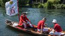 Petugas Penanda Angsa (Swan Marker) menyusuri Sungai Themes selama kegiatan Sawn Upping di dekat Shepperton, Inggris, Senin (17/7). Dari atas kapal berbendera, tim sensus mencari angsa-angsa yang sedang berenang untuk ditangkap. (CHRIS J RATCLIFFE / AFP)