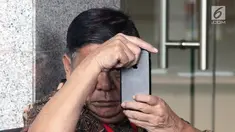 Mantan Bupati Buton Laode Muhammad Sjafei Kahar bermain ponsel saat menunggu untuk menjalani pemeriksaan di lobi gedung KPK, Jakarta, Rabu (17/7). Sjafei Kahar merupakan ayah Bupati Buton Selatan nonaktif Agus Feisal. (Merdeka.com/Dwi Narwoko)