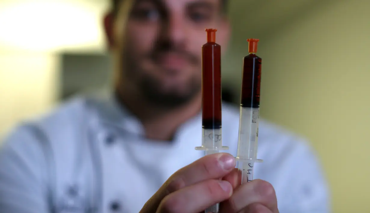 Chef Christopher Sayegh memperlihatkan, minyak THC (Tetrahydrocannabinol), dan CBD (Cannabidiol) yang akan digunakan sebagai campuran bahan masakan di sebuah restoran di Los Angeles, AS (29/4). (Reuters/ Mario Anzuoni)