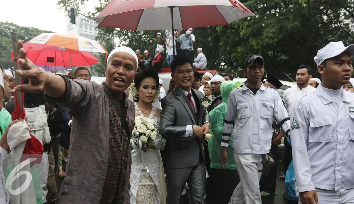 Sepasang mempelai dikawal sejumlah orang dari ormas islam untuk menuju Gereja Katedreal, Sabtu (11/2). Pasangan mempelai ini dibantu oleh sejumlah orang yang tergabung dalam massa Aksi 112. (Liputan6.com/Herman Zakharia)