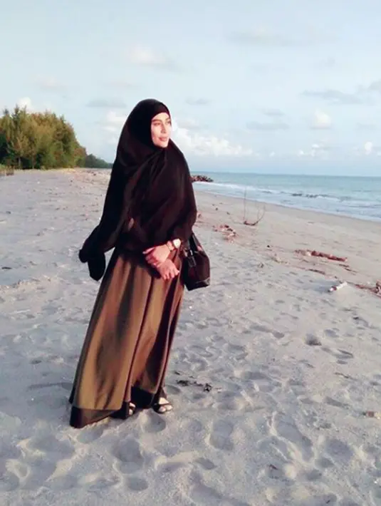 Penyanyi dangdut Cinta Penelope berpose di sebuah pantai dengan mengenakan hijab. Pelantun 'Keong Racun' ini tak ragu lagi menuliskan kata-kata yang lebih agamais di media sosialnya. (Instagram/princess_cinta_penelope)