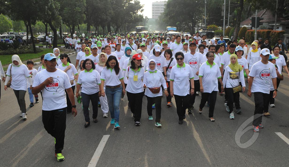 Istri Wakil Presiden Jusuf Kalla (tengah) berjalan bersama para peserta fun walk 2015, Jakarta, Minggu (29/3/2015). acara ini dalam rangka memperingati hari autisme sedunia yang jatuh tanggal 2 april setiap tahunnya. (Liputan6.com/Herman Zakharia)