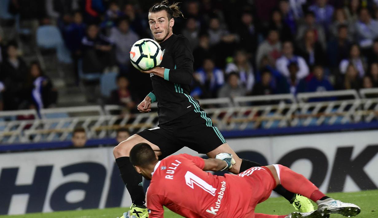Striker Real Madrid, Gareth Bale, berusaha melewati kiper Real Sociedad, Geronimo Rulli, pada laga La Liga di Stadion Anoeta, Minggu (17/9/2017). Real Madrid menang 3-1 atas Real Sociedad. (AP/Alvaro Barrientos)