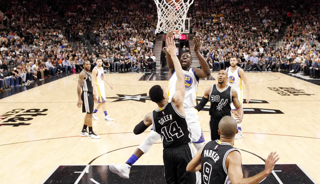 Pemain Golden State Warriors, Draymond Green (23), melakukan dunk saat dihadang pemain San Antonio Spurs, Danny Green (14), pada lanjutan NBA di AT&T Center, San Antonio, (10/4/2016). Warriors menang 92-86. (Reuters/Soobum Im-USA Today Sports)