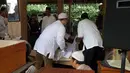 Sejumlah kerabat tampak mengkafani jenazah Didi Petet di musala di rumah kediaman almarhum di kawasan ciputat, Tangerang Selatan, Jumat (15/5/2015). Didi Petet meninggal di usia 58 tahun karena diduga menderita asam lambung. (Liputan6.com/Helmi Afandi)