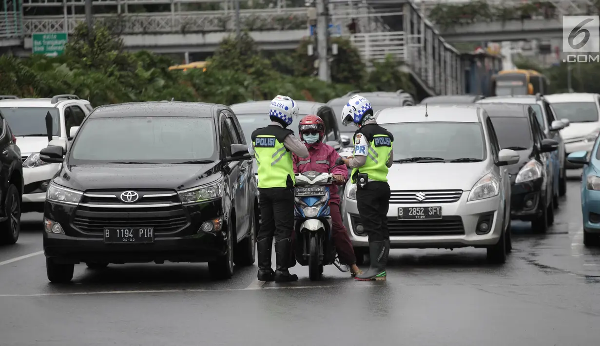 Polisi melakukan tindakan tilang kepada pengendara motor yang melanggar aturan jalur khusus sepeda motor di Jalan MH Thamrin-Medan Merdeka Barat, Jakarta Pusat, Kamis (8/2). (Liputan6.com/Arya Manggala)