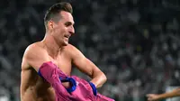 Masih di masa injury time, Juventus kembali membobol gawang Salernitana lewat aksi Arkadiusz Milik. Selebrasi sambil membuka jersey pun akhirnya berbuah kartu kuning kedua untuk Arkadiusz Milik. (AFP/Isabella Bonotto)