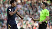 Wasit asal Spanyol, Cesar Soto Grado (kanan) sedang memimpin pertandingan Real Madrid di Liga Spanyol musim ini. Tampak ia sedang berbincang dengan Jude Bellingham. (CRISTINA QUICLER / AFP)