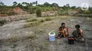 Dua warga menunggu giliran untuk mandi di Sungai Cipamingkis, Desa Jagaita, Jonggol, Kabupaten Bogor, Jawa Barat, Kamis (29/7/2021). Warga mandi dan mencuci pakaian di aliran Sungai Cipamingkis lantaran sumur di rumah mereka mengalami kekeringan sejak satu bulan lalu. (merdeka.com/Iqbal S. Nugroho)