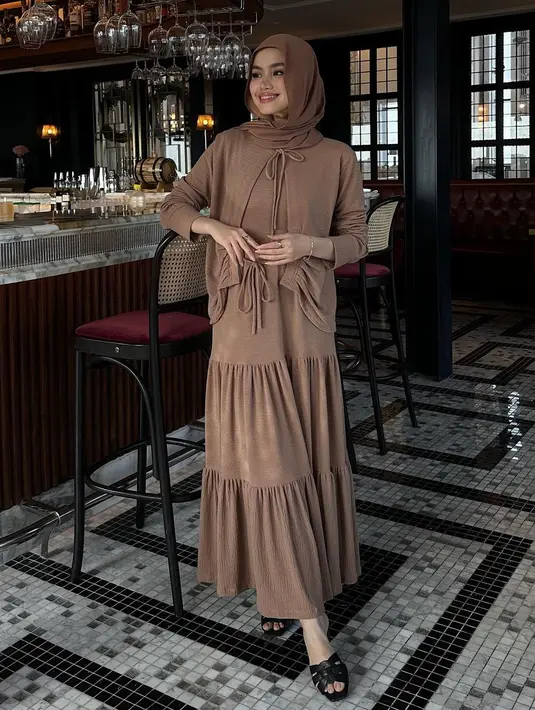 Sashfir mengenakan gamis ruffle dengan outer coklat yang warnanya senada dengan gamis dan hijabnya. @sashfir