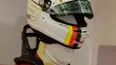 Pembalap Ferrari Sebastian Vettel dari Jerman memakai helmnya selama latihan bebas pertama di Sirkuit Internasional Formula One Bahrain di Sakhir, Bahrain, (6/4). Sebelumnya, Sebastian Vettel menjuarai balapan F1 GP Australia. (AP Photo/Luca Bruno)