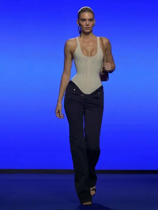 Kendall pun memamerkan koleksi Schiaparelli dengan atasan sleeveless siluet korset putih memiliki aksen garis. Cukup dipadukan dengan celana denim panjang. [@kendalljenner]