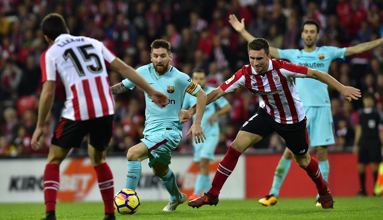 Bintang FC Barcelona, Lionel Messi berusaha melewati adangan pemain Athletic Bilbao, Inigo Lekue (kiri) dan Aymeric Laportez pada lanjutan La Liga Santander di San Mames stadium, Bilbao, (28/102017). Barcelona menang 2-0. (AP/Alvaro Barrientos)
