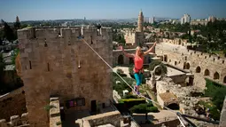 Slackliner Amerika, Heather Larsen saat beraksi melintasi dua menara Museum David di Yerusalem 2 Mei 2016. Museum David yang dikenal dengan museum "Biblical king" ini dilewati Larsen dengan tenang. (REUTERS / Nir Elias)
