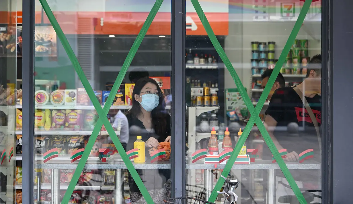 Orang-orang berbelanja di sebuah minimarket dengan jendela yang ditutup rapat saat Topan Super Ragasa mendekati Zhuhai, Provinsi Guangdong, Tiongkok Selatan, pada Selasa 23 September 2025. (Adek BERRY/AFP)
