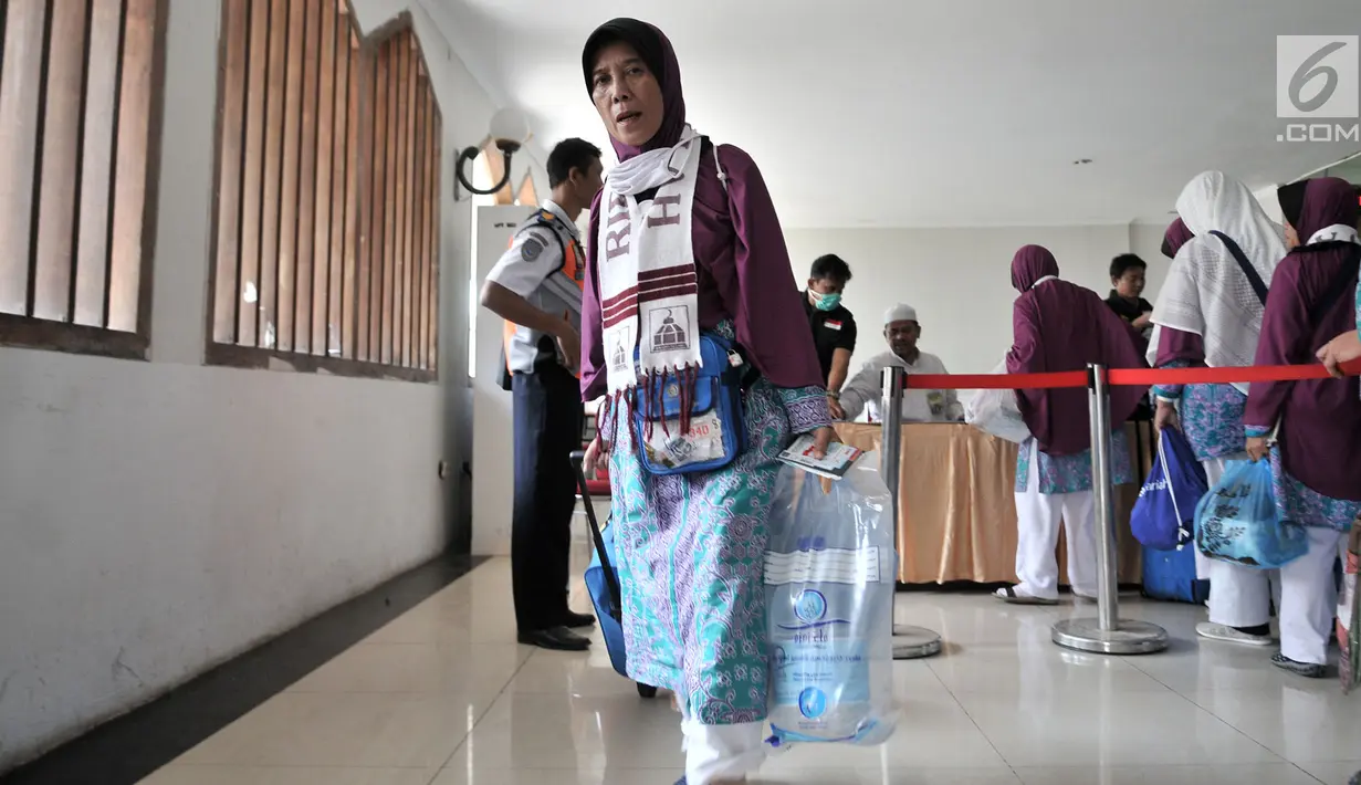 Jemaah haji Kloter 2 asal Banten membawa air zam-zam yang dibagikan di Asrama Haji Pondok Gede, Jakarta, Rabu (29/8). Panitia Penyelenggara Ibadah Haji (PPIH) membagikan air zam-zam  lima liter per jemaah secara cuma-cuma. (Merdeka.com/ Iqbal S. Nugroho)