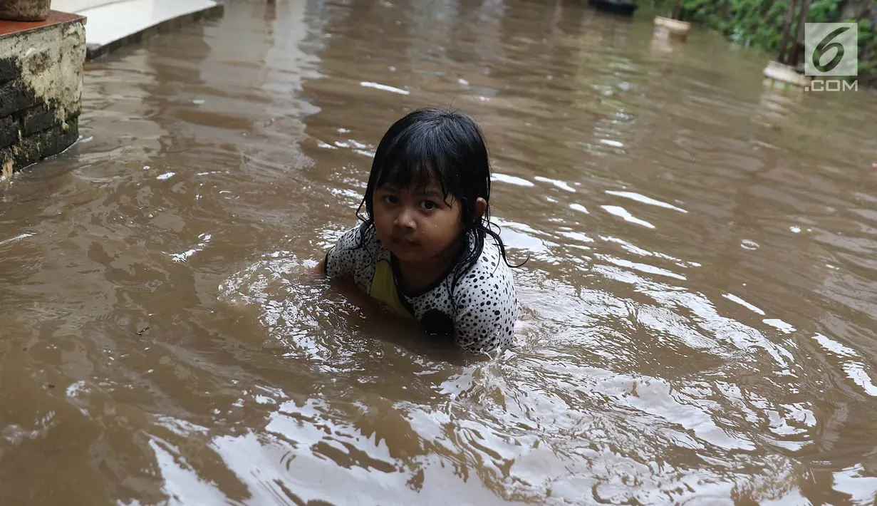 Seorang anak bermain air saat banjir menggenangi kawasan Cilandak Timur, Jakarta Selatan, Selasa (22/1). Hujan deras yang mengguyur Jakarta dan sekitarnya sejak pagi menyebabkan banjir di sejumlah sudut Ibu Kota. (Liputan6.com/Immanuel Antonius)