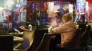 Pemain dan pekerja meja permainan dipisahkan oleh plexiglass saat pembukaan kembali hotel dan kasino Bellagio, Las Vegas, Nevada, Amerika Serikat, Kamis (4/6/2020). Kasino di Nevada diizinkan kembali beroperasi setelah penutupan sementara untuk mencegah penyebaran COVID-19. (Ronda Churchill/AFP)