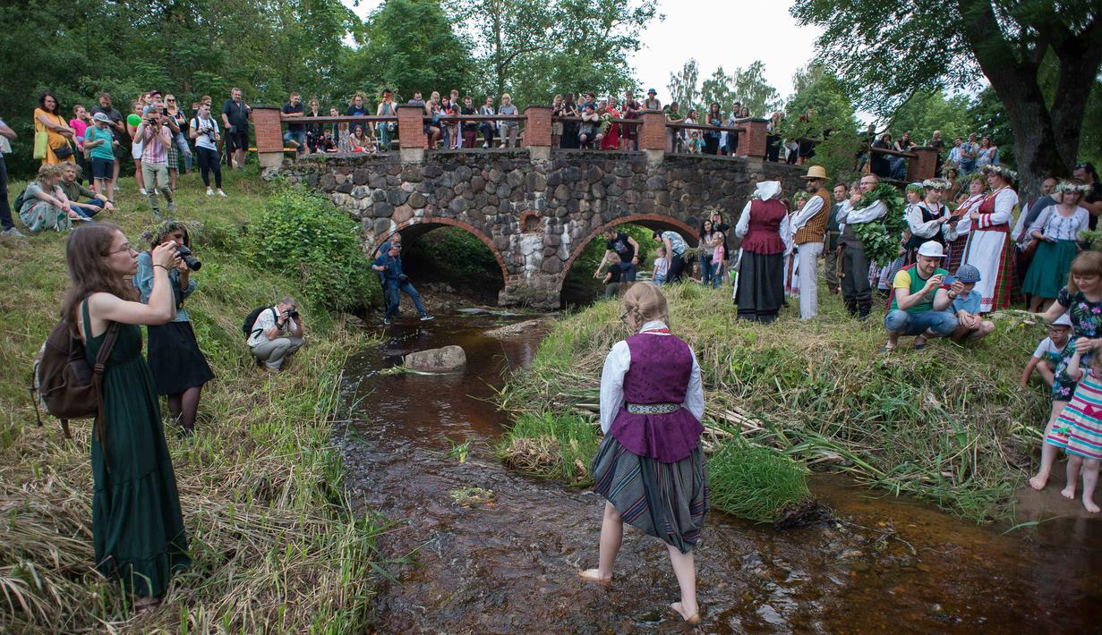 Sejumlah warga mengikuti Festival Rasos di Rumsiskes, Lithuania, Selasa (23/6/2020). Orang-orang merayakan festival ini dengan mengenakan sejumlah hiasan bunga dan kostum tradisional serta bernyanyi dan menari. (Xinhua/Alfredas Pliadis)