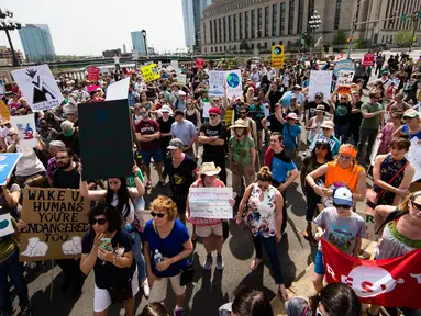 Sejumlah orang melakukan demonstrasi bertepatan 100 hari kerja Trump sebagai presiden di Market Street di Philadelphia, AS, Sabtu (29/4). Demonstran memprotes kebijakan Presiden Donald Trump terkait perubahan iklim. (AP Photo / Matt Rourke)