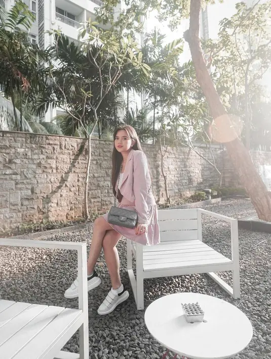 Kombinasi blazer  dan celana pendek pink, dipadukan inner putih dan sneakers bikin looks ibu satu anak ini makin modis. (Instagram/audimarissa).