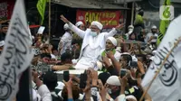 Rizieq Shihab menyapa massa pendukungnya saat tiba di kediamannya di Jalan Petamburan, Jakarta, Selasa (10/11/2020). Rizieq Shihab tiba di kediamannya usai pulang dari Arab Saudi. (merdeka.com/Imam Buhori)