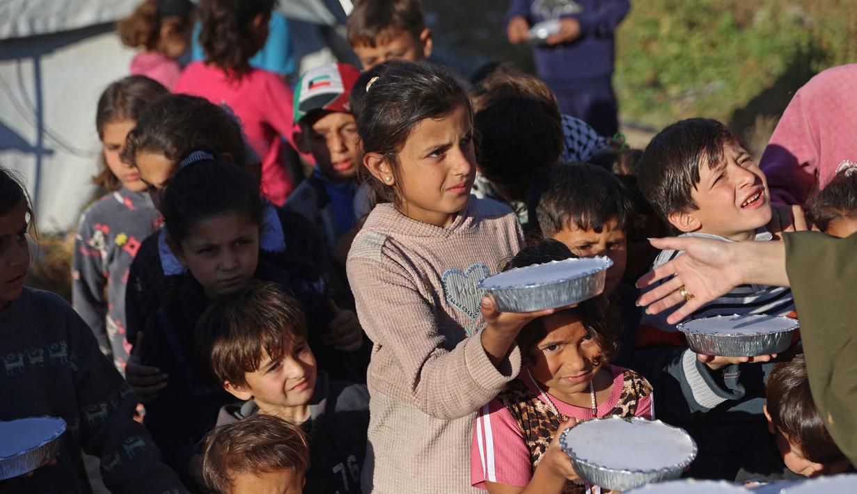 Bahkan, Gaza telah memasuki fase darurat berdasarkan sistem Integrated Food Security Phase Classification (IPC). Tampak dalam foto, anak-anak pengungsi menerima paket makanan gratis dari kakak beradik Palestina, Lina Zeid dan Aya Zeid, di daerah Al-Tuam, sebelah barat Jabalia, Jalur Gaza Utara pada Rabu 6 Mei 2026. (Omar AL-QATTAA/AFP)