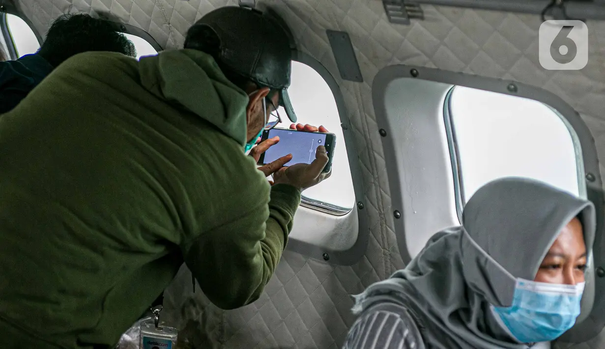 Sejumlah awak media memantau proses pencarian pesawat Sriwijaya Air SJ 182 dari pesawat CN 295 milik TNI AU di perairan Kepulauan Seribu, Jakarta, Minggu (10/1/2021). TNI AU menargetkan proses pencarian Sriwijaya Air SJ 182 maksimal selama tujuh hari. (Liputan6.com/Faizal Fanani)
