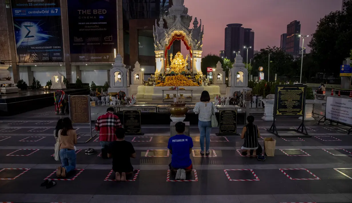 Umat berdoa di dalam area yang ditandai untuk jarak sosial di sebuah kuil untuk dewa Hindu Ganesh, di luar pusat perbelanjaan di Bangkok, Thailand, Selasa (29/12/2020). Thailand mengumumkan kematian pertamanya akibat virus corona COVID-19 sejak November. (AP Photo/Gemunu Amarasinghe)